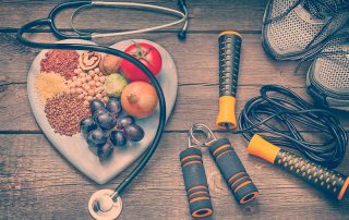 Medicina do estilo de vida, comida saudável, acessórios para exercícios e um estetoscópio.